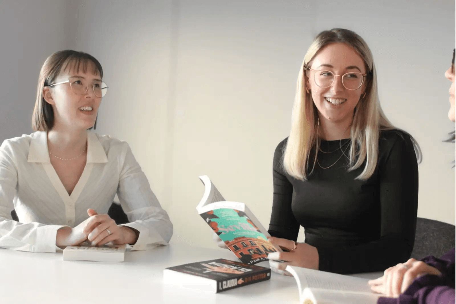 Two Libero team members discussing a book with an author
